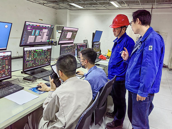 5月13日，動(dòng)力車間三期鍋爐控制室，DCS改造工藝、儀表、電氣等部門聯(lián)合調(diào)試，車間主任姜軍虎與技術(shù)員畢加佳查看調(diào)試過(guò)程.jpg