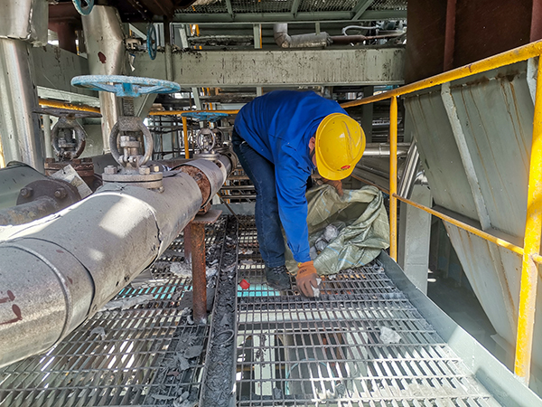 101744267062809801.jpg 班組青工張跟潮清理現場檢修垃圾.jpg