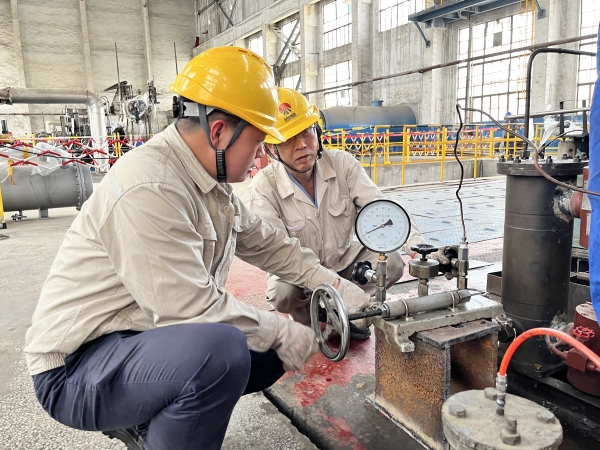 161744795121176525.jpg 圖為師傅吳培榮指導(dǎo)徒弟陳東操作校驗(yàn)儀.JPG